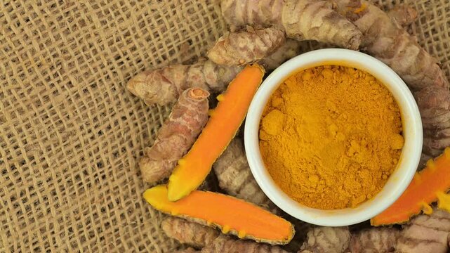 Tumeric fresh and powdered, top view, rotating 