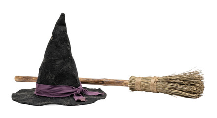 Black felt witch hat with a purple ribbon and a rustic wooden broomstick on white background © Sapphire