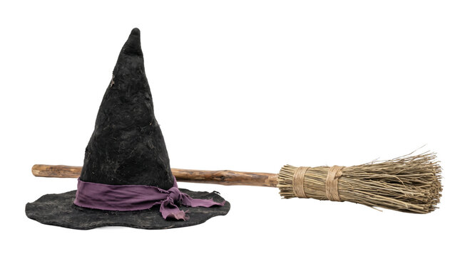 Black felt witch hat with a purple ribbon and a rustic wooden broomstick on white background