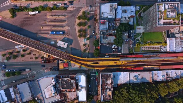 Bird's eye view on the railways crossing the modern cityscape. Two train move to opposite sides of the city. Transport system of New York City, USA.