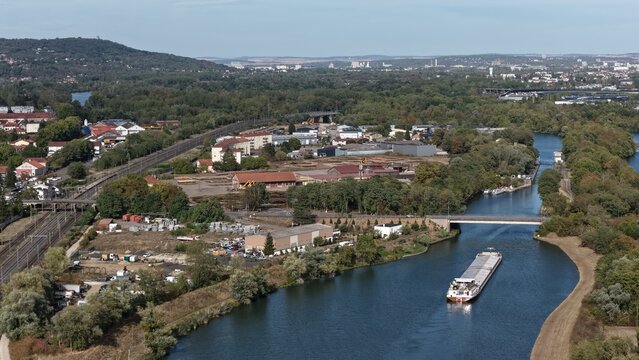 vue a&eacute;rienne panoramique de la Moselle canalis&eacute;e avec une p&eacute;niche qui circule en direction de Metz entre les villages d'Ars-sur-Moselle et de Jouy-aux Arches. France septembre 2026