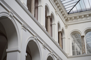 Bright interior atrium with arches, stone columns and large glass ceiling © barmaleeva