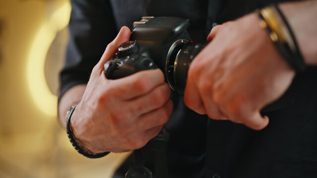 Close up photographer hands adjusting settings dial DSLR camera studio