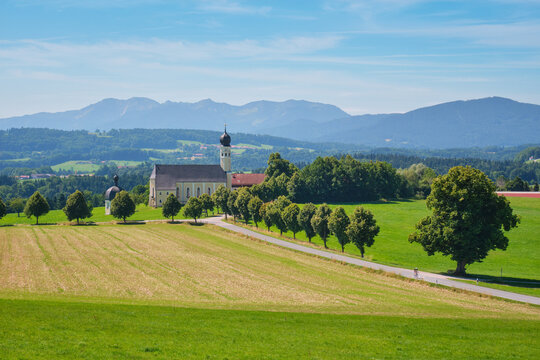 Scenic view of the St. Marinus and Anianus pilgrimage church (Wilparting) against the Bavarian Alps in Irschenberg, Bavaria, Germany.