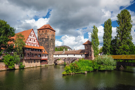 View of the historic timber-framed Weinstadel and Henkersteg bridge crossing the Pegnitz river in Nuremberg city, Germany.