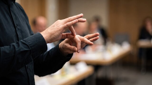 Hands Demonstrating Sign Language Interpretation at Community Meeting