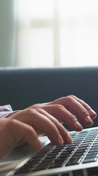 Close up of woman typing on laptop at home