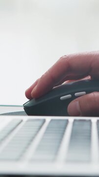 Hand using computer mouse in office settin