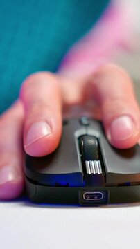 Hand clicking black computer mouse on white desk