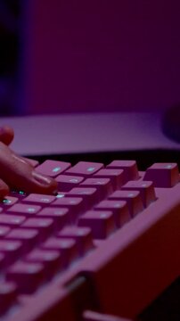 Typing on illuminated pink computer keyboard