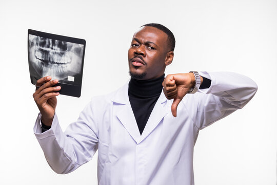 Unimpressed doctor holding a dental X-ray giving a thumbs down in critique of medical results or diagnosis