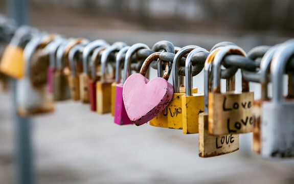Heart-shaped padlock on a line of locks on a chain