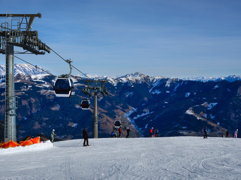 Skiers and gondola lift on a mountain top at Zell am See