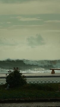 Stormy ocean waves crash over a nearly destroyed waterfront