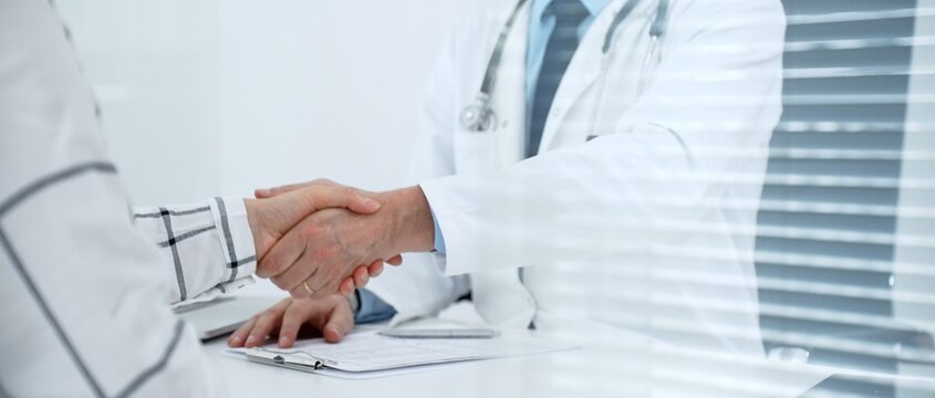 Doctor and patient handshake at medical office, symbolizing trust, agreement, and partnership in healthcare, during a consultation for medical support and treatment