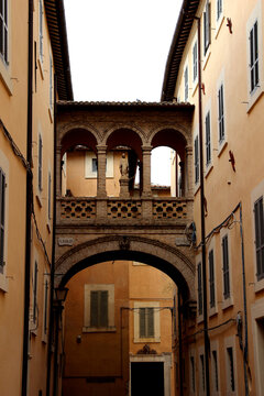 SPOLETO, ITALY - FEBRUARY 7, 2017: Arco del Seminario. An elevated covered archway located in the historic center of Spoleto, connecting two historic buildings, with a small statue of the Madonna