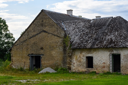 Side view of a historic limestone estate building with structural alterations, a steel lintel opening, and a moss-covered slate roof at Aa Manor.
