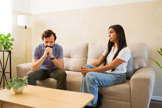 Troubled couple facing relationship problems at home, experiencing conflict, sadness, and an argument about their breakup
