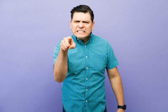 Angry man pointing his finger, showing aggression and blame. He is arguing, scolding, and expressing frustration