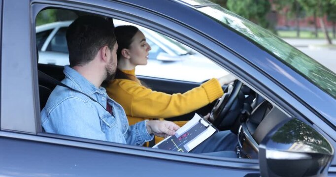 Woman having driving lesson with instructor in car