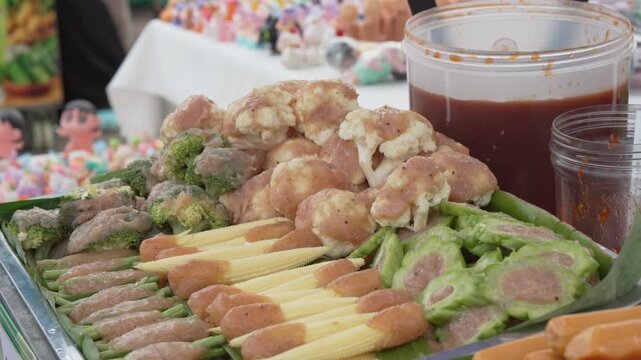 Assorted grilled skewers with vegetables at a street market