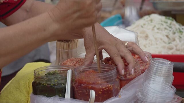 Street vendor serving colorful food with dipping sauces