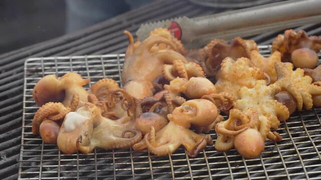 Grilled squid rings and seafood skewers on a rack