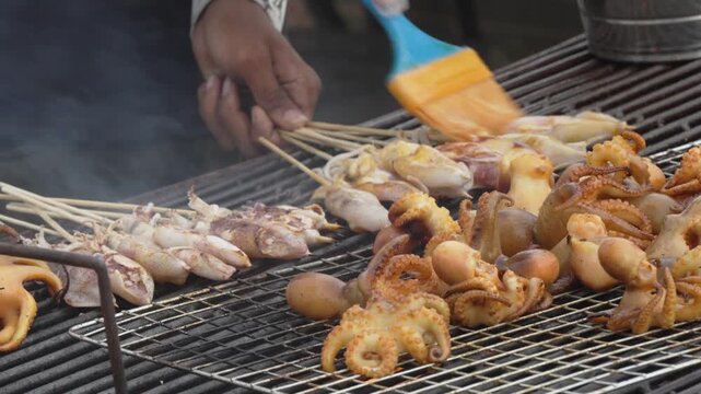 Assorted squid skewers cooking at a street food stall