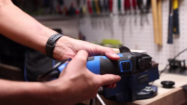 Powered oscillating cut off tool buzzes through piece of wood in small home work shop