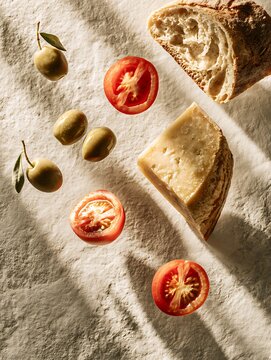 Mediterranean Appetizer Still Life with Parmesan Cheese, Cherry Tomatoes, Olives and Crusty Bread