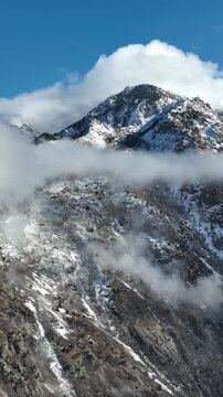 Aerial shot of the clouds and the rugged terrain of the Wasatch Mountains near Salt Lake City, Utah. Vertical Video.