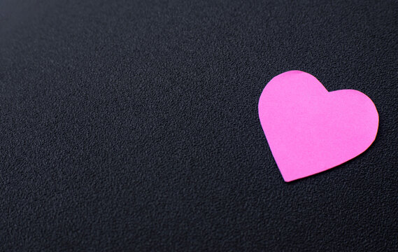 Pink Paper Heart On Minimal Dark Black Background, simple conceptual image for love, romance, affection, and emotional themes.