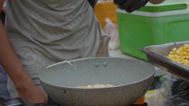 Cooking a savory food mixture in a large wok at a street market