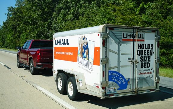 Kent County, Delaware, U.S.A - Sept 9, 2026 - A red Chevy Silverado pickup towing U-Haul trailer promoting self-moving services along Route 1 highway