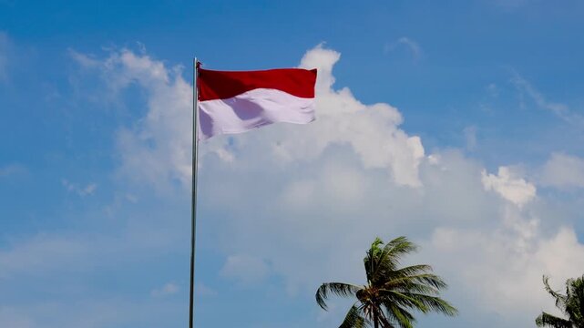 flag of indonesia. Red and white flag waves against a bright blue sky