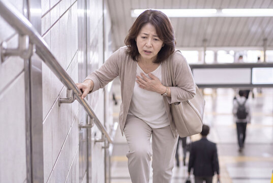 駅の階段を上って息切れする中高年女性