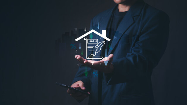 Corporate businessman presents virtual house hologram with a loan contract and downward percentage arrows for a real estate mortgage rate decrease and a property finance investment concept.