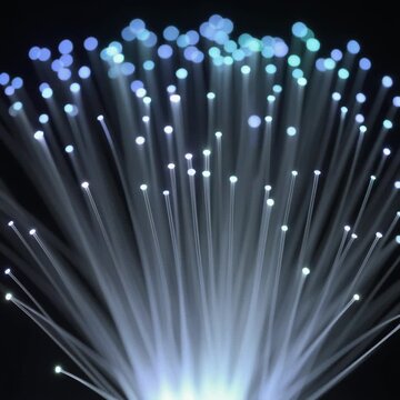 Abstract background of glowing fiber optic cables transmitting data in the dark.