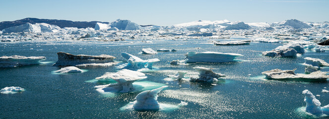 Climate Change and Global Warming - Icebergs and ice from melting glacier in icefjord in Ilulissat, Greenland. Aerial photo of arctic nature ice landscape.  Panoramic banner © Maridav