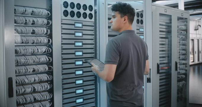 Network Specialist Works Directly With Server Cabinet Controls, Reviewing LED Indicators and Making Adjustments During Equipment Inspection Inside Large Modern Data Center With Infrastructure.