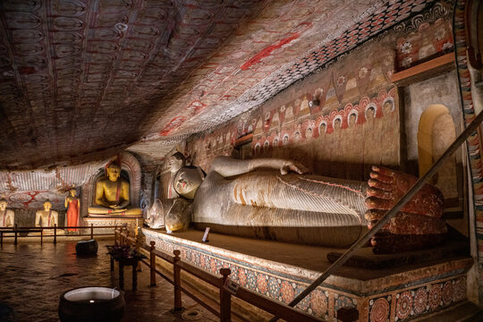 Reclining Buddha statue and ancient ceiling murals inside cave shrine at Dambulla Cave Temple. The Dambulla Cave Temple, also known as the Rangiri Dambulla Cave Temple