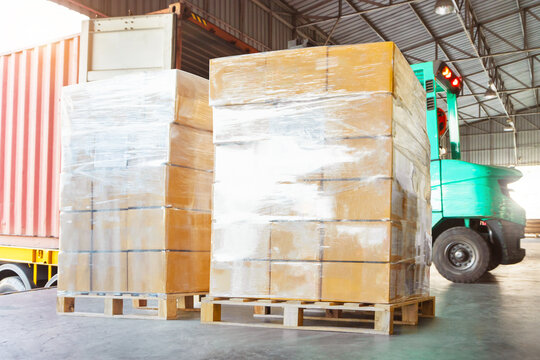 Goods awaiting loading into shipping containers. bulk of package boxes shipment. freight truck transportation. distribution warehouse, import-export shipment. warehouse logistics