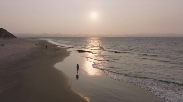 persona caminando en la playa a la hora del sunset en Organo Piura