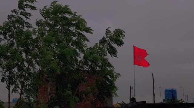 Saffron Om Flag Waving in Strong Stormy Wind Under Overcast Sky in India