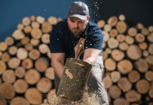 Man Chopping Firewood with Axe and Flying Wood Chips