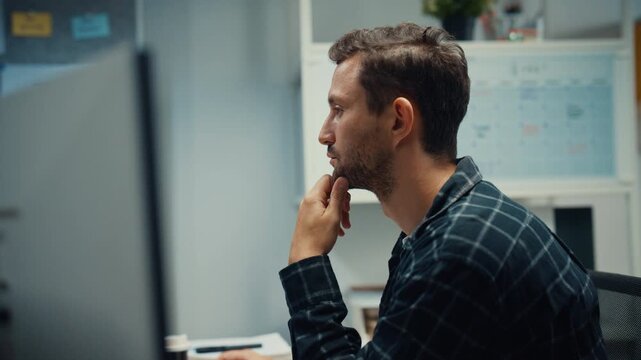 Young Caucasian male programmer writes code using multiple screens in home office workspace. AI development, cybersecurity, network database system, software engineering, remote tech startup concept.