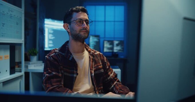 Young Caucasian male programmer write code on computer in home office at late night. AI technology, cybersecurity, software developer, freelance innovation, database system, digital network concept.