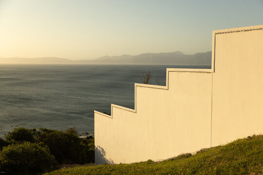 stair step design of wall overlooking Walker Bay, DeKelders, South Africa at sunset