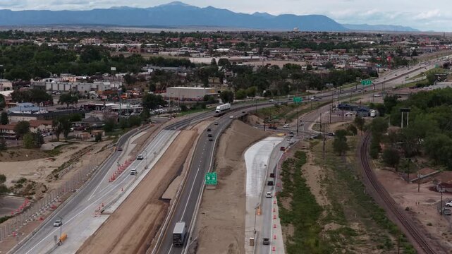 Aerial of I25 highway construction in Pueblo Colorado with distant mountains and urban sprawl along railroad tracks