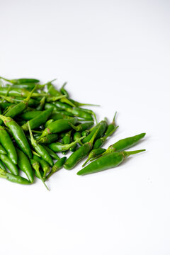 Close-up heap of fresh green bird's eye chilies or cabe rawit hijau as spicy culinary ingredients